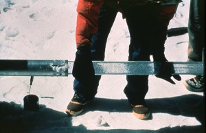 This photograph shows an ice core sample being taken from a drill. Photo by Lonnie Thompson, Byrd Polar Research Centre, Ohio State University. From Wikimedia Commons.